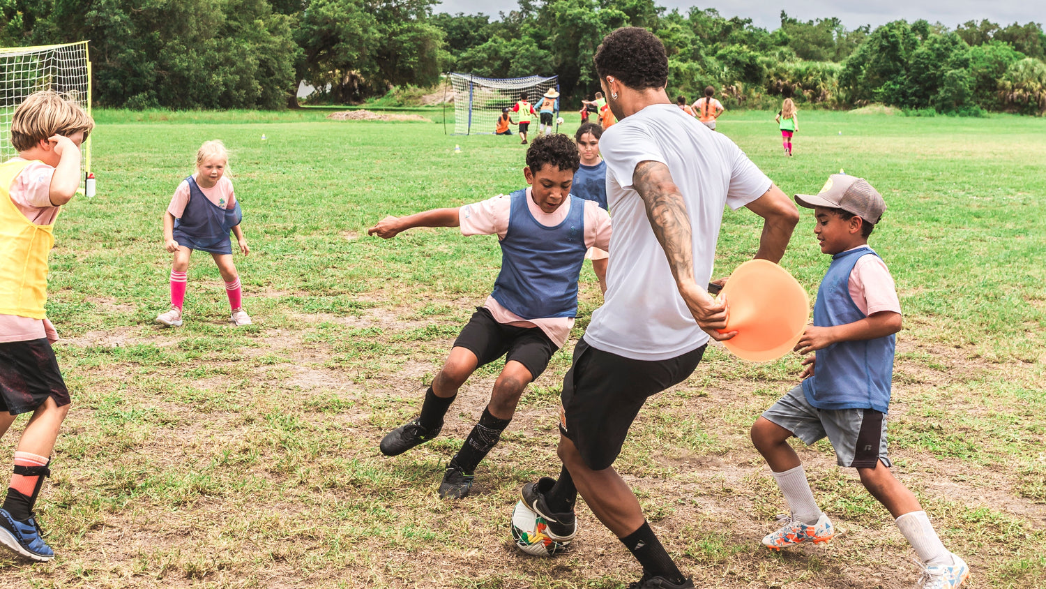 Children playing with a frisbee on a grassy field under a cloudy sky.
